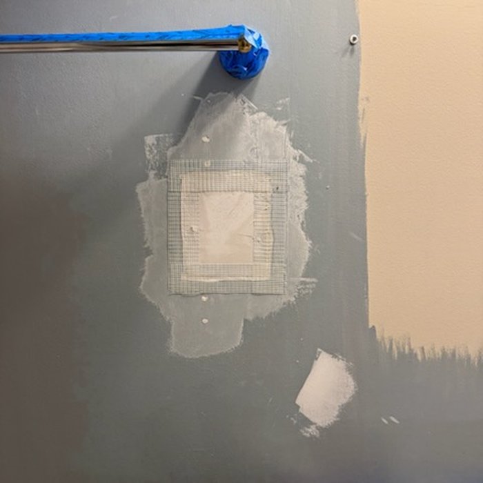 Fiberglass mesh tape applied over patch